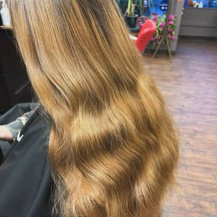Long golden brown hair styled in soft waves, viewed from behind.